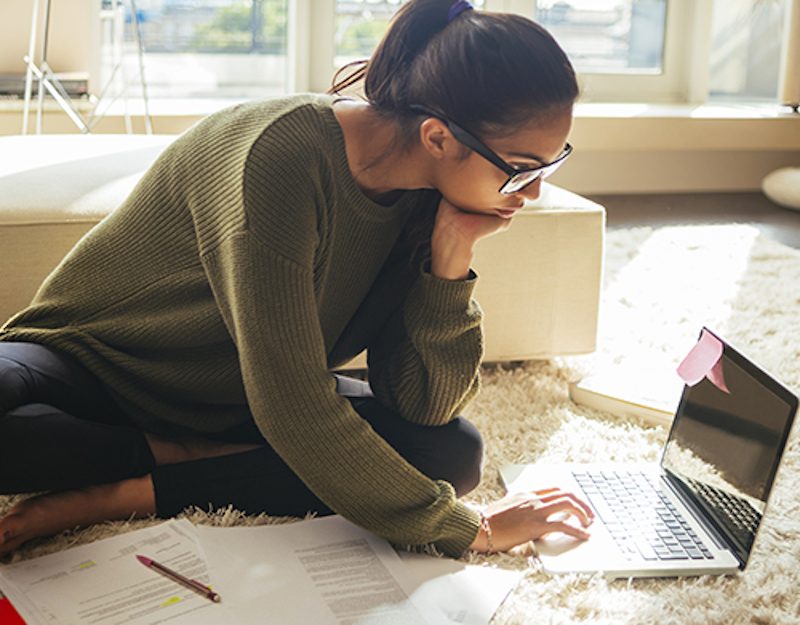 woman leaning over laptop on table