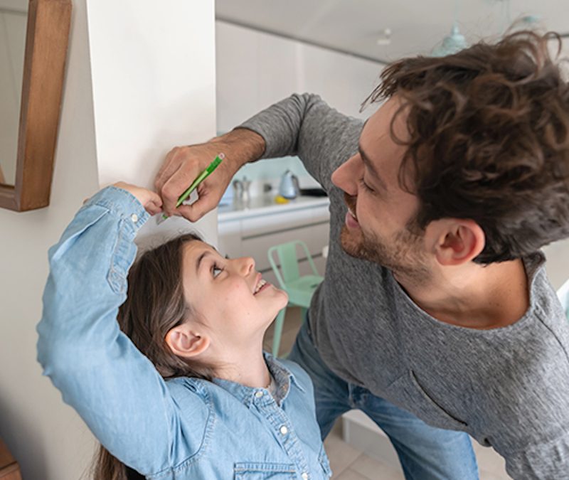 kid and dad measuring height
