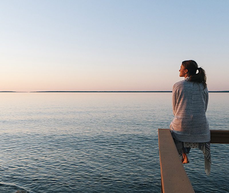 girl on bench infront of beach